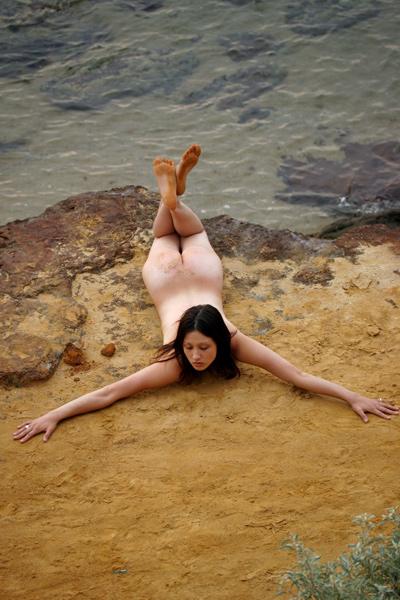 Fully naked stunner hides her pussy among the rocks in Met Art set Jacinta