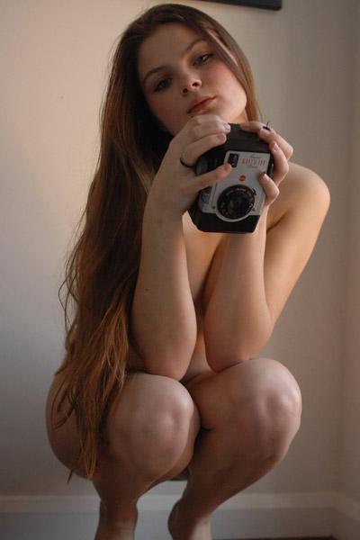 Nymphette jeune laissant la lumière du soleil toucher sa peau sans défaut dans les soufflets se mettre en photo